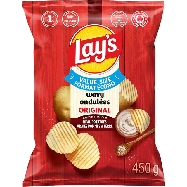 Lay's Wavy Original Potato Chips Value Size 450g bag with red wood plank background, featuring ridged potato chips, a whole potato, and a wooden spoon with salt beside a chip dipped in creamy dip, highlighting real potatoes and Canadian-made branding, suitable for dipping and snacking.