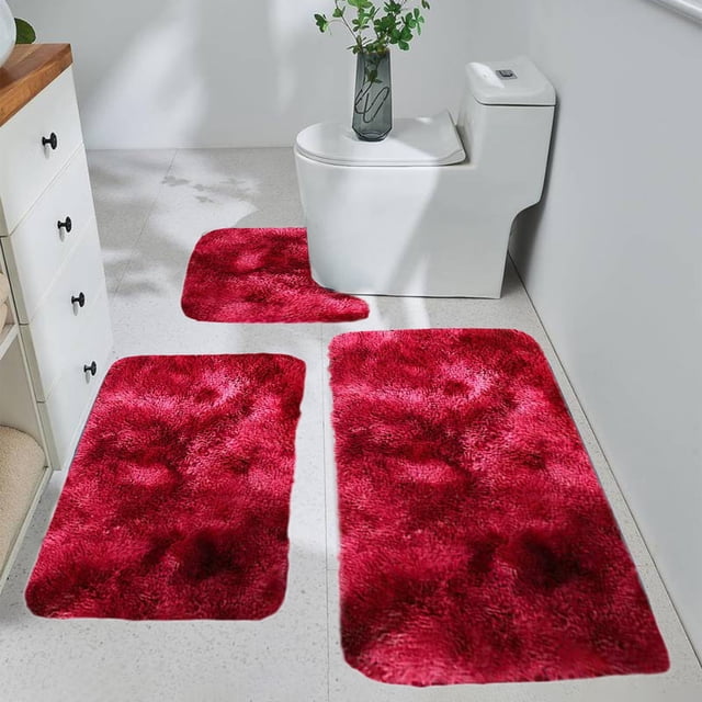 Sokhug Bathroom Rugs Sets 3 Clearance Toilet Bath Mat with U-Shaped, in a bold red color and soft coral velvet texture. The set includes a rectangular bath mat, a U-shaped toilet mat, and a smaller mat, all with non-slip rubber backing for stability. These water-absorbent, quick-drying mats are machine washable and suitable for bathrooms, powder rooms, or other spaces. Shown in a clean, modern bathroom with a white toilet and vanity.