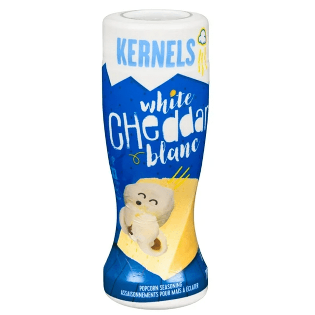 Kernels Assaisonnements Extraordinaires pour Maïs Soufflé Cheddar Blanc dans une Bouteille shaker Bleu et Blanc Présentant un Personnage Ludique de Maïs Soufflé et un Quartier de Fromage Cheddar Blanc, Conçus pour Enrober Uniformément le Maïs Soufflé d'Une Saveur Crémeuse et Salée et Convenant Aussi à l'Assaisonnement d'Autres Collations.