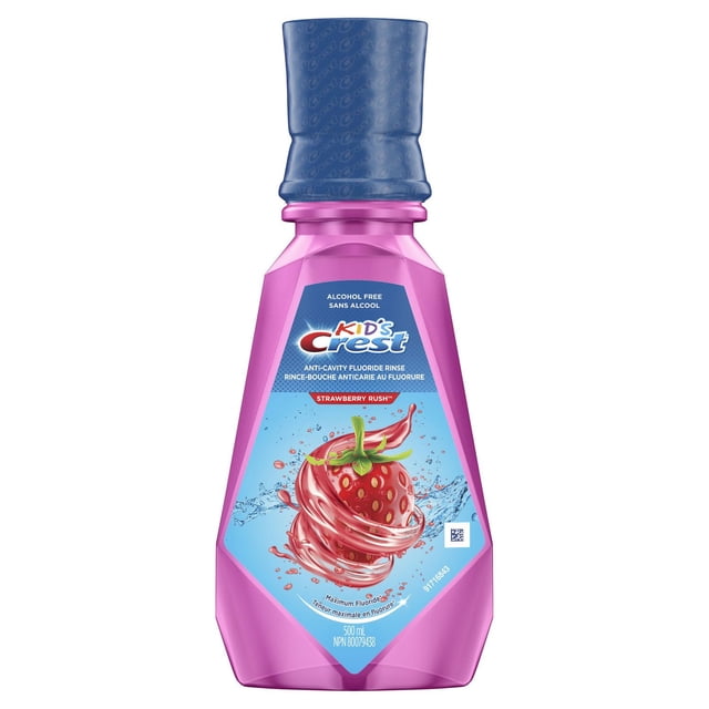 Crest Kid's Anticavity Alcohol Free Fluoride Rinse in a 500 ml pink plastic bottle with a blue cap, featuring a label with a strawberry swirl graphic, alcohol free and designed for kids 6 and up, providing anticavity fluoride protection and a strawberry rush flavour for oral care.
