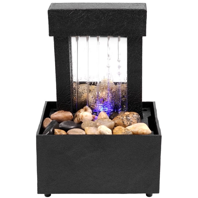 Dosaele Tabletop Fountain with Light, a mini indoor water fountain featuring a black ABS plastic frame with cascading water illuminated by soft blue light. The fountain includes natural pebbles at the base and is powered by USB or 2 AA batteries. Compact design suitable for home, office, or meditation spaces.