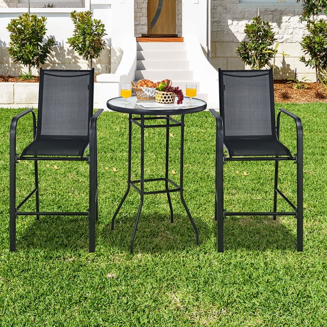 Costway Ensemble de 3 Pcs pour Bar de Patio Extérieur avec Tabouret, Comprenant un Plateau Rond en Verre Trempé et Deux Tabourets de Hauteur de Bar avec Tissu Noir Respirant et Accoudoirs Ergonomiques. l'Ensemble Est Exposé sur une Pelouse Verte avec une Maison Moderne en Arrière-Plan, Idéal pour les Espaces Extérieurs comme les patios, les Jardins Ou le Bord de la Piscine.