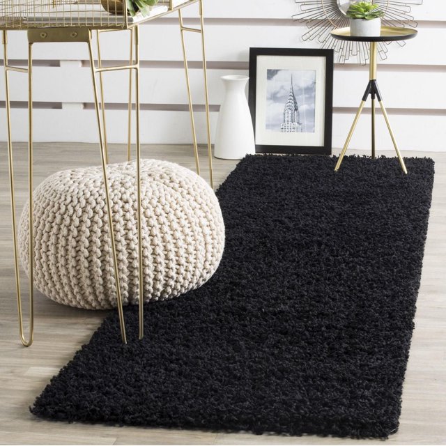 Safavieh Athens Tapis Shag en Peluche Uni Noir, Rectangulaire avec une pile de Polypropylène dense Proposant une Sensation Pelucheuse sous les Pieds. Exposé sur un Plancher de Bois Clair avec un pouf Tricoté Crème, table d'Appoint à Pattes en Métal Doré Tenant une Plante, photo Encadrée Noir et Blanc, et vase Blanc, Convient aux Intérieurs Modernes et Traditionnels de Transition.