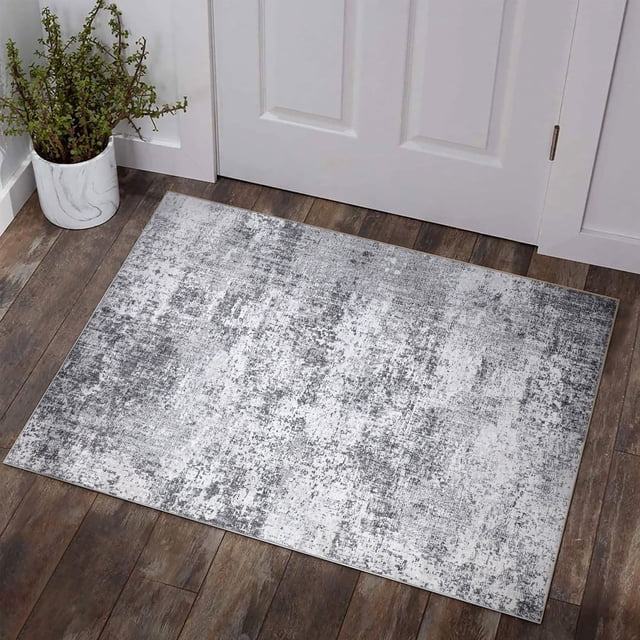 BERTHMEER 2'x3' abstract area rug in gray, displayed in an entryway with a distressed design. Made of polyester and thermoplastic rubber, this low-pile rug is stain-resistant, machine washable, and non-slip. Ideal for living rooms, bedrooms, dining rooms, offices, and farmhouses, and part of the washable rugs category.