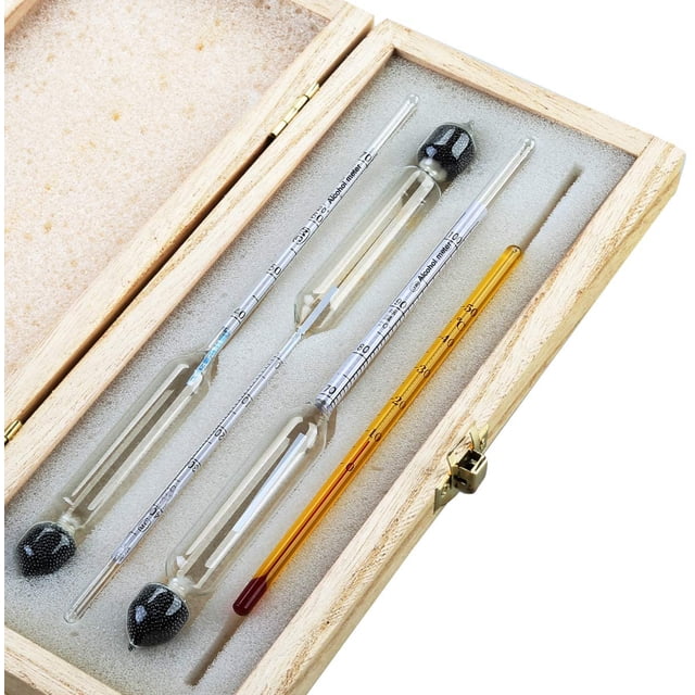 Professional Alcohol Meter Set with 3 hydrometers graduated from 0-100% and a thermometer, ideal for distilling and liquor production. The set is displayed in a wooden storage box with foam padding, featuring transparent glass hydrometers with clear graduations for precise alcohol content measurement in spirits like whiskey, vodka, and cognac. Includes a thermometer for temperature monitoring during testing.