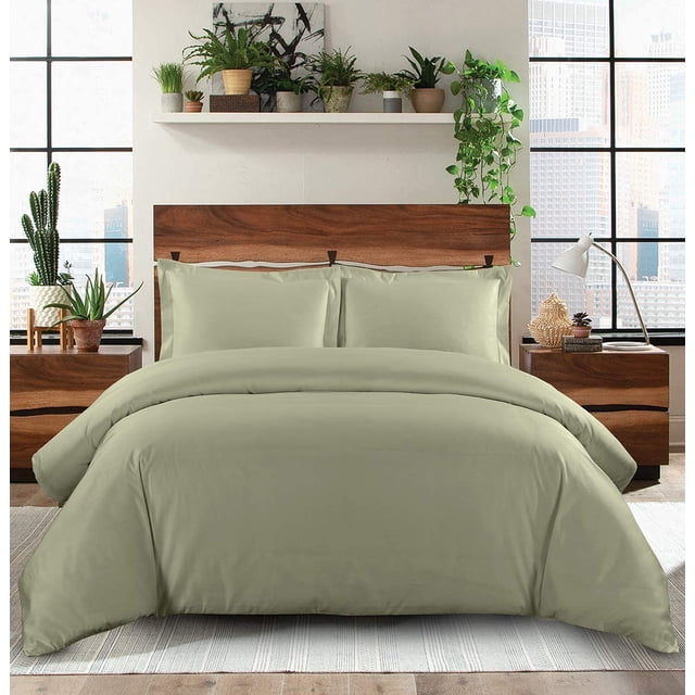 Housse de Couette 1200 TC 100 % Coton Égyptien avec Fermeture Éclair Dissimulée, Montrée en Vert Atténué sur un Lit Très Grand. le Tissu Ultra Doux et durable Résiste à la Décoloration, Offrant une option de Literie Luxueuse et Légère. la Housse de Couette Est Exposée dans un Cadre de Chambre Moderne avec une Tête de Lit en Bois, des Plantes d'Intérieur et de Grandes Fenêtres.