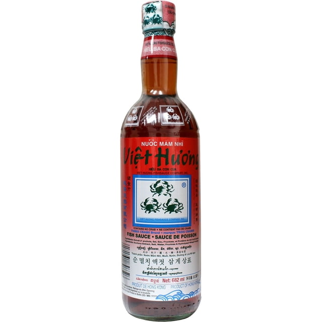 THREE CRABS BRAND FISH SAUCE in a 682 ml clear glass bottle with amber liquid and a red label featuring three green crab logos and multilingual text. Produced by Viet Huong Fishsauce Company using traditional fermentation, this authentic Southeast Asian condiment enriches marinades, soups, and stir-fries with rich umami flavor and serves as a versatile pantry staple.