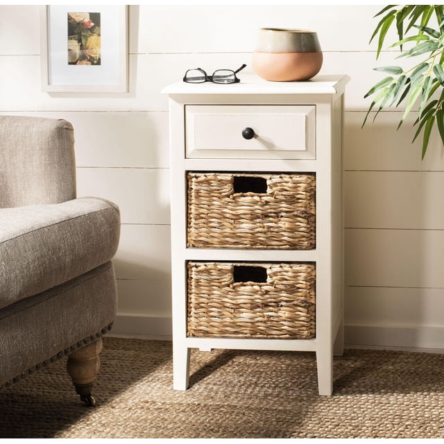 Safavieh Table d'Appoint Everly Contemporaine avec Tiroir et Deux Paniers en Pin Vieilli Blanc vintage, avec un Tiroir avec un Bouton Noir et Deux Paniers Tissés Amovibles, Installée sur un Tapis en Fibre Naturelle à Côté d'Une Chaise Rembourrée beige, avec un Imprimé floral Encadré et une Plante Verte, Idéale pour la Déco de Ferme Ou de Chalet Côtier et Convient pour Organiser les Essentiels du Salon.