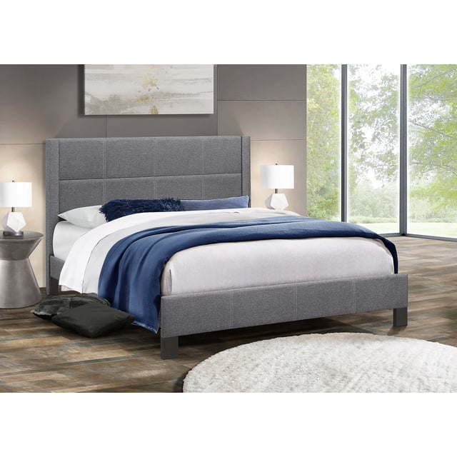 Lit Plateforme Orné de Tissu Capitonné en Gris Foncé, avec une Tête de Lit Capitonnée à Surpiqûres Contrastantes. Offert en Formats Simple, Double et Grand. le Lit Est Présenté dans un Cadre de Chambre Moderne avec de Grandes Fenêtres, un Tapis Gris et des tables de Chevet avec des Lampes. Comprend un support de Matelas, Aucun Sommier Requis.