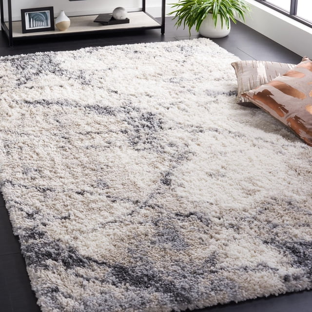 SAFAVIEH FNT834A WHITE 7X9 Fontana shag area rug with 2-inch plush pile, featuring a tonal abstract pattern in white, beige, and gray on a dark hardwood floor, ideal for living rooms and accent spaces, often used to add comfort and style underfoot.