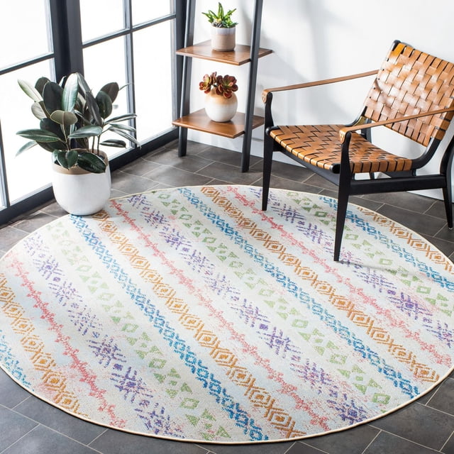 Safavieh Summer Joella Geometric Striped Area Rug, round with multicolored geometric stripes in blue, orange, green, purple, and red on white, placed on dark tile floor beside a woven leather chair and wooden shelf with plants, suitable for indoor or covered outdoor use.
