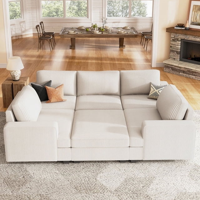 HONBAY Canapé Sectionnel Modulable en Velours Côtelé Convertible en Lit pour Salon en beige, Présenté dans un Salon Lumineux avec une table à Manger en Arrière-Plan. le Sofa Présente un Tissu en Velours Côtelé Doux, une Conception Modulable pour des arrangements Flexibles, et une Fonction de Couchage pour les Hébergements d'Invités. Il Comprend des Housses de Dossier Amovibles et Lavables pour un Nettoyage Facile et un ottoman avec un Rangement Spacieux. les Dimensions Sont de 65 Pouces de Profondeur, 93,8 Pouces de Largeur et 35 Pouces de Hauteur.