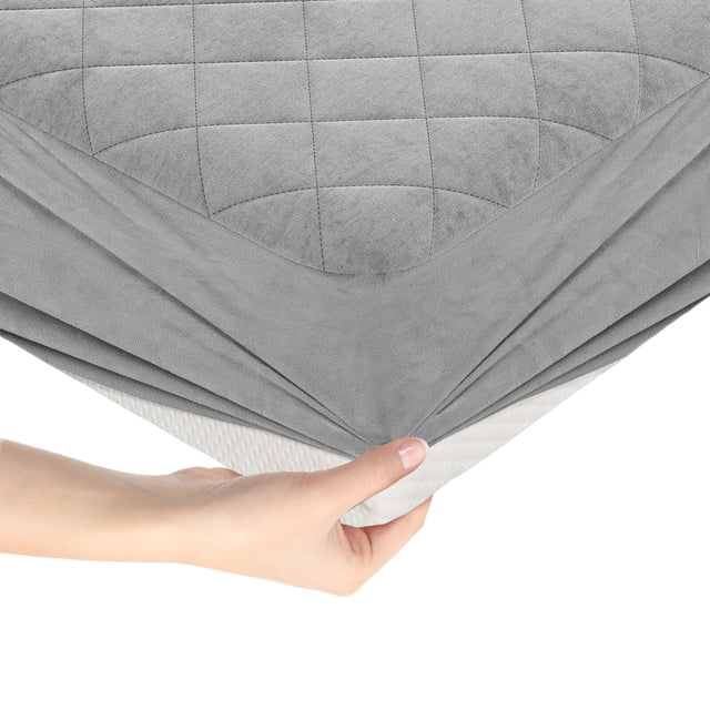 Costway King Size Mattress Protector with Deep Pocket Sponge Padding in gray, featuring a breathable velvet surface with square jacquard stitching for durability. The elastic pocket fits mattresses up to 16 inches thick, ensuring a secure fit. The non-slip bottom adds stability, while the multi-layer sponge padding provides comfort and protection against dirt and damage. A hand is shown stretching the elastic skirt over a mattress corner.