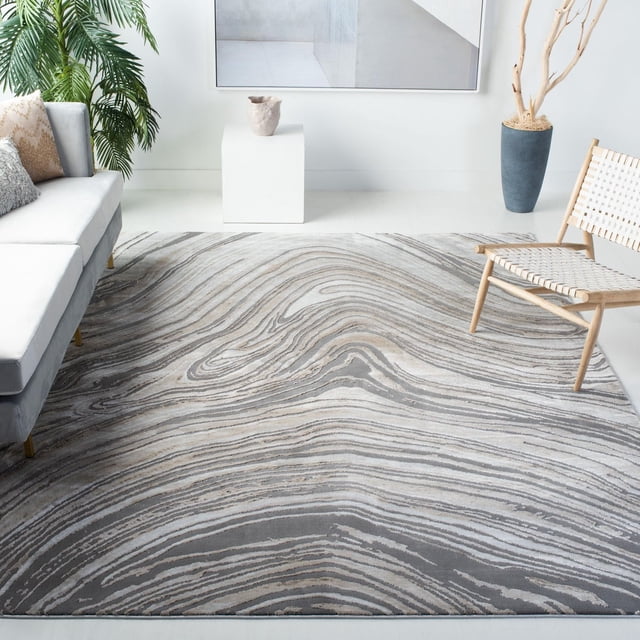 SAFAVIEH Craft Lula Abstract Area Rug featuring swirling grey and beige abstract patterns with a subtle etched pile texture, displayed in a contemporary living room with a grey sofa, woven wooden chair, and potted plant. Ideal for adding texture and modern flair to home decor.