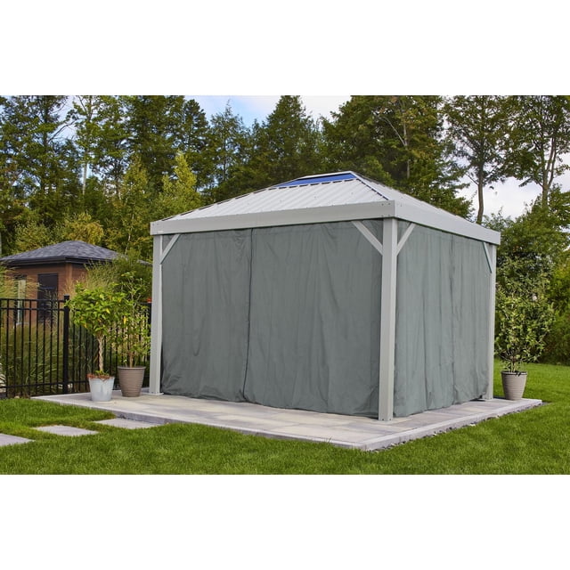 Sojag Skylight 10 x 12 x 7 ft Grey gazebo with grey spun polyester curtains featuring zippers for privacy and sun protection, placed on a stone patio with green grass and potted plants in a backyard outdoor living space