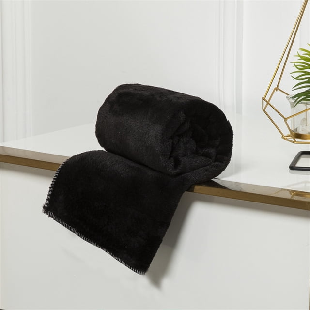 TIMIFIS Throw Blanket couch throw blanket in black, crafted from super soft warm micro plush fleece material. The blanket is rolled and displayed on a white surface with a decorative gold wire frame and plant in the background. Lightweight and cozy, it measures 70x100cm, ideal for sofas, beds, or outdoor use.