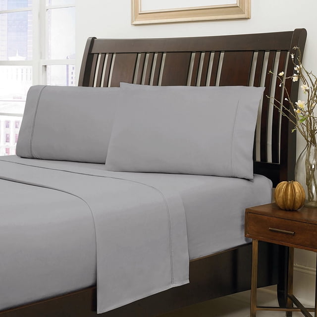 Johnson Home 500 Thread Count Certified Organic Cotton Sheet Sets in light grey on a dark wood slatted bed frame with matching pillowcases and flat sheet, beside a wooden nightstand with a decorative pumpkin and glass vase with flowers, featuring breathable, hypoallergenic organic cotton bedding ideal for year-round comfort and sensitive skin.