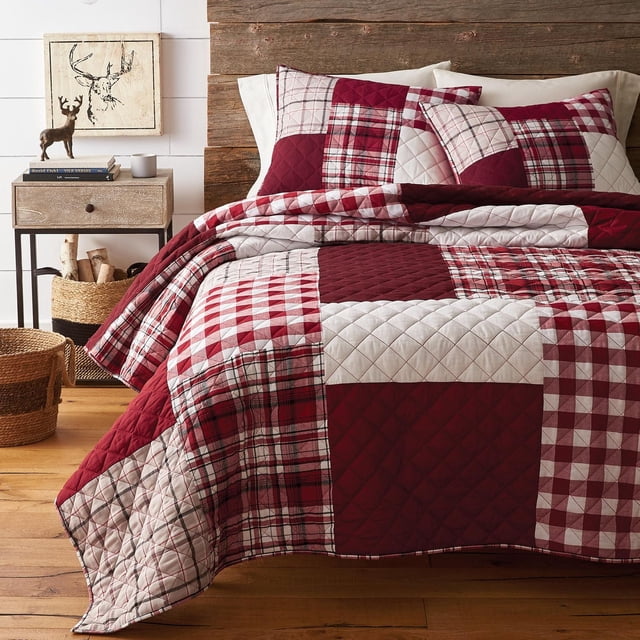 Canadiana 3pc Red Plaid Quilt Set King with a patchwork design of red, white, and burgundy plaid and solid cotton quilted squares, including matching pillow shams. Made of 100% cotton with recycled polyester fill, machine washable and easy care. Ideal for rustic or country-style bedrooms.
