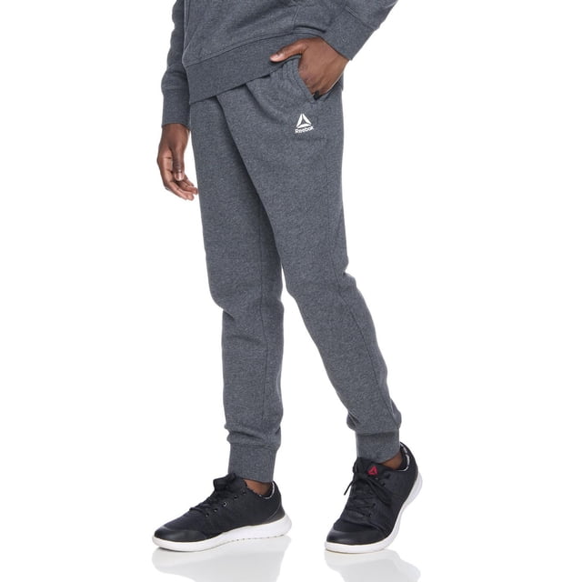 Reebok Jogger en Molleton Delta pour Garçons en Tissu Polaire de Base Gris Foncé avec Taille Élastique et Cordon de Serrage Intérieur, Deux Poches Latérales Incluant une Poche à Fermeture Éclair Collée, Poignets Côtelés et logo Delta Blanc sur la Cuisse Gauche, Idéal pour l'École, les sports Ou les Tenues Décontractées.