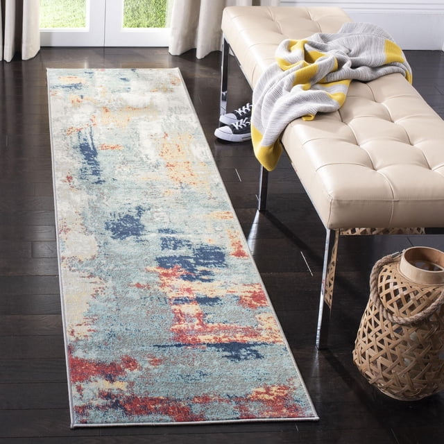 SAFAVIEH Jasper Alvina Abstract Overdyed Area Rug runner with soft cut pile made of durable synthetic yarns, featuring an abstract pattern in muted blues, reds, and beige on dark hardwood floor beside a beige tufted bench with a gray and yellow throw blanket, suitable for high-traffic areas.