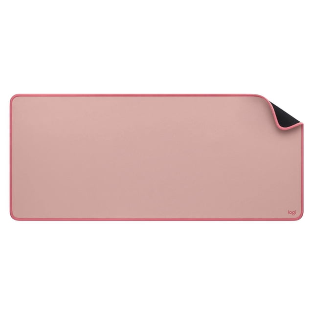 Logitech Desk Mat - Studio Series in dark rose, a large rectangular desk mat with rounded corners, soft cloth surface and pink stitched edges, corner flipped to reveal black anti-slip rubber base and small 'logi' logo, ideal for protecting and organizing office desks.