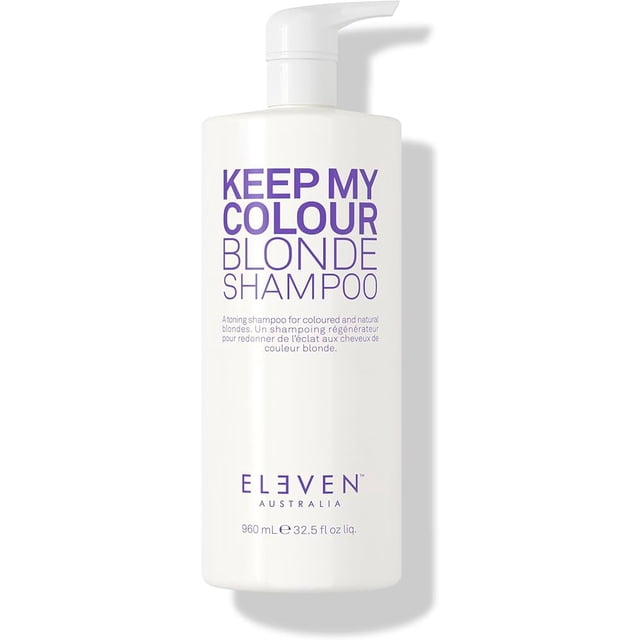 Eleven Australia Keep My Colour Blonde Shampoo in a 960ML (32.5Fl oz) bottle. This toning shampoo is designed for coloured and natural blondes, offering anti-fade and colour-safe properties. The product is vegan-friendly, sulfate-free, and features a pump dispenser for easy use. The bottle is white with bold purple text and the Eleven Australia logo at the bottom.