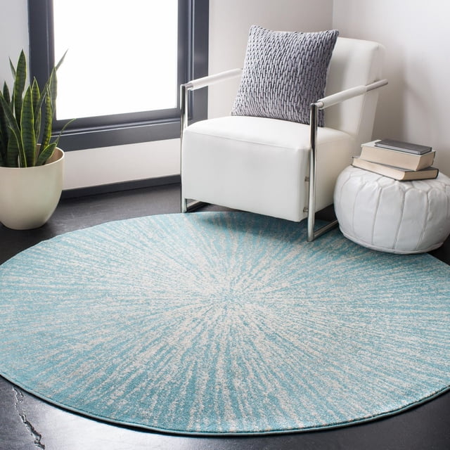 Safavieh Evoke Vana Abstract Geometric Area Rug, round with a blue and beige radial pattern and power-loomed polypropylene frieze texture, placed on a dark floor beside a white modern armchair with a gray woven pillow, a white leather pouf with books, and a snake plant near a window, ideal for adding style and comfort to living areas.