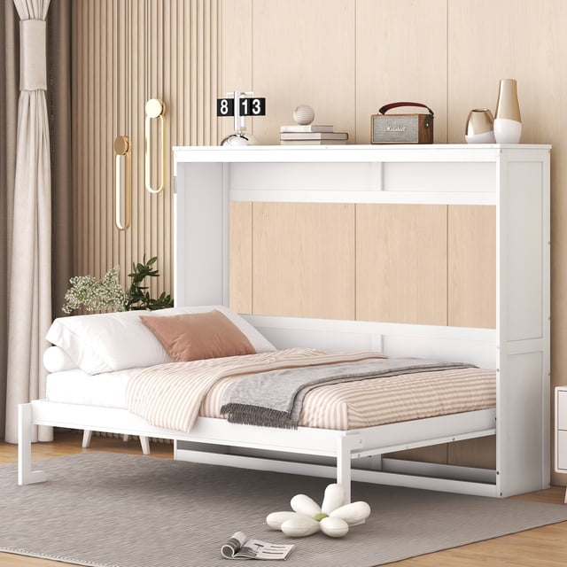 Noble House Lit Escamotable Mural Pleine Grandeur en Blanc, Montré Déplié dans une Chambre Moderne avec des Murs et des Rideaux en Panneau de Bois beige. le Cadre de Lit Est en MDF Laminé et du Contreplaqué avec des accents de Panneau de Bois Clair, Supportant un Matelas Pleine Grandeur avec une Literie Rayée beige et Blanche, un Jeté Gris et un Oreiller Brun. Il Présente un Cadre en Métal Blanc avec une Poignée à Tirer et une Jambe Rabattable pour une Installation Facile. la Pièce Comprend des Appliques Murales Dorées, un Tapis Gris avec un Coussin en Forme de Fleur Blanche, et des Articles Décoratifs