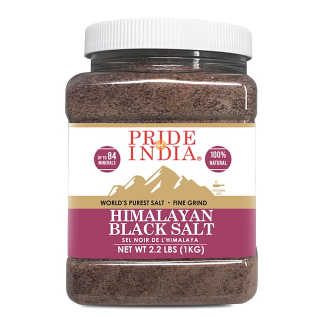 Pride of India Himalayan Black Salt - Fine, 35.3 oz (1000.75 g), packaged in a clear plastic jar with a white lid. The label highlights its natural composition, containing up to 84 essential minerals, and its use for cooking, bath salts, and therapeutic purposes. The blackish salt is finely ground and sourced from the Himalayan mountains.