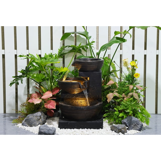 Fontaine d'Eau à Bol en Cascade de 24 Pouces en Gris avec Conception à Plusieurs Niveaux et Lumières DEL Blanc Chaud. Fabriquée en Polyrésine durable, Elle Offre un Débit d'Eau Stable avec une Pompe de 450 L/h et une Capacité d'Eau de 5,5 Litres. la Pompe de Fontaine Assure une circulation Efficace, Entourée de Verdure Luxuriante et de Galets Blancs Décoratifs, Idéale pour une Utilisation Extérieure dans les Jardins Ou les patios.