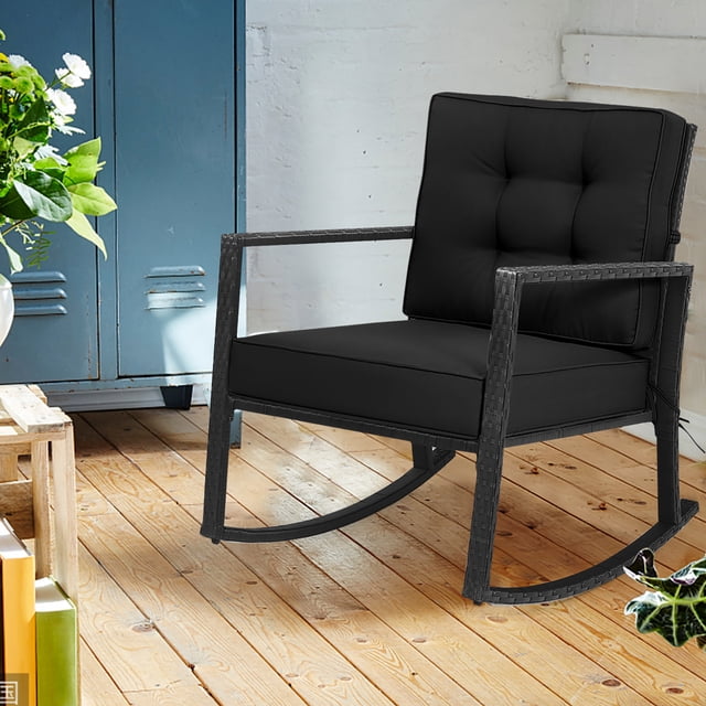 Costway Patio Rattan Rocker Chair Outdoor Glider Rocking Chair Cushion Lawn Black Front-facing black PE rattan glider with metal frame, angled backrest and slightly downward handrails. Thick seat (5 in) and back (3.5 in) cushions tied by strings, anti-slip pads at feet; also suitable as an indoor accent or reading chair.