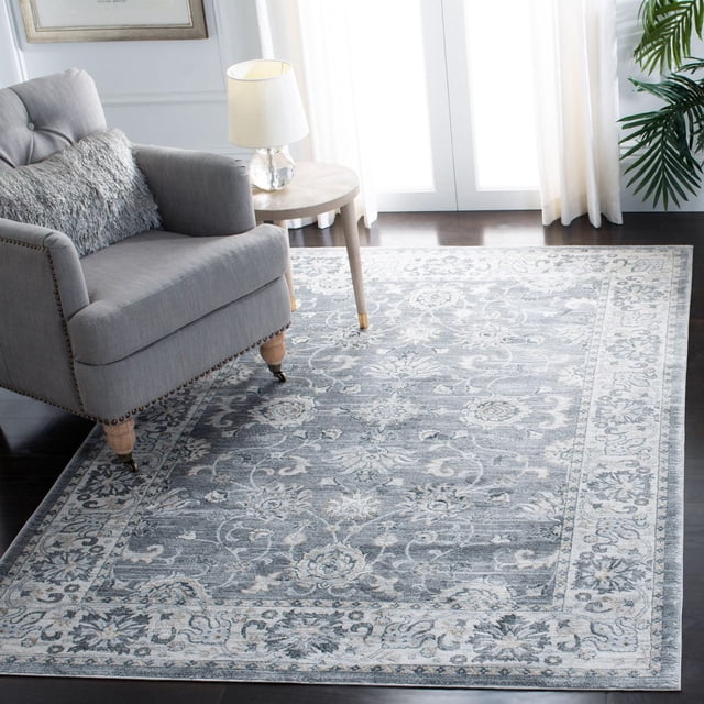 SAFAVIEH Isabella Kiana Tapis à Bordure Florale avec motifs Floraux Traditionnels dans des Tons Gris Doux et Bleus, Tufté Mécaniquement, Poil Synthétique de Coupe Moyenne, Montré sur Plancher de Bois Franc Foncé à Côté d'Un Fauteuil Rembourré Gris et d'Une table d'Appoint Ronde avec Lampe, dans une Pièce Lumineuse avec des Rideaux Blancs et une Plante Verte, Idéal pour une Déco d'Accent Classique Ou Décontractée.