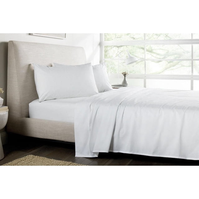 Johnson Home Ensembles de Draps en Coton Peigné 500 Fils en Blanc sur un Lit Rembourré beige avec une Haute Tête de Lit, Présentant un Tissu en Coton Lisse et Respirant avec une Finition Satinée, Exposés dans une Chambre Éclatante avec de Grandes Fenêtres et une Lumière Naturelle.