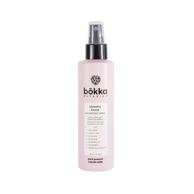 Bokka Botanika Spray Volume Blowdry Boost in a 6oz (177ml) bottle. The product features a sleek, light pink bottle with a black spray nozzle and the Bokka Botanika logo prominently displayed. Designed for fine, limp hair, this alcohol-free formula adds volume, thickness, and shine while protecting hair color with its COLORLOKK COMPLEX. Enriched with apple, sugarcane, and green tea extracts, it provides weightless body and texture without stickiness or flaking.