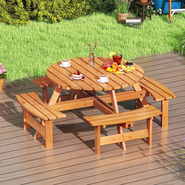 Costway 8-Person Round Picnic Table Set with 4 Built-in Benches and a 2-inch umbrella hole, shown in yellow. The set includes a 44-inch round table and four curved benches, crafted from sturdy fir wood with a weatherproof finish. The table and benches are placed on a wooden deck in a backyard setting, surrounded by grass and plants. The table is styled with plates, cups, and food items, showcasing its use for outdoor dining.