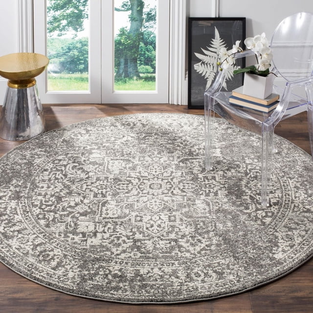 Safavieh Evoke Trena Tapis Traditionnel, un Tapis Rond durable avec un Motif Médaillon Traditionnel en Gris et Blanc Cassé, Fait de Fil de Polypropylène à Haute Torsion Frise à Poil Coupé, Placé sur un Plancher de Bois Franc Près des Portes en Verre avec une Chaise en Acrylique Transparent Tenant des Livres et une Orchidée Blanche, et une table d'Appoint Argentée et Dorée, Idéal pour Ajouter de la texture et du style aux Espaces de Vie.