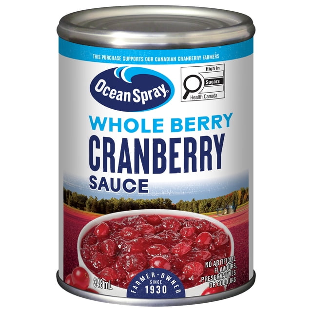Ocean Spray Whole Berry Cranberry Sauce 348 mL can with a front label featuring the brand logo, bold blue product name, and a bowl of whole cranberry sauce. The label highlights no artificial flavours, preservatives, or colours, and notes farmer-owned since 1930 with a cranberry field and tractor background. Suitable for adding tangy flavour to meals or sandwiches.