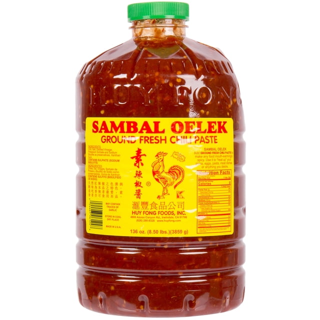 Huy Fong 8,5 lb Pâte de Piment Sambal Oelek Fraîche Moulue dans un Grand Pot en Plastique avec Couvercle Vert à Vis. le Pot Présente une Étiquette Jaune Vibrante avec Texte Rouge et un logo de Coq, Mettant en Valeur les Détails du Produit et des Informations Nutritionnelles. la Pâte de Piment à l'Intérieur Est Visiblement Texturée avec des Graines et des Morceaux de Piment, Mettant l'Accent sur Sa Couleur Rouge Ardente et Sa composition Fraîche Moulue. Idéale pour les Plats Thaïlandais et Vietnamiens, Cette Pâte