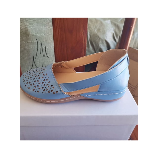 Woobling Ladies Wedges Solid Color Sandals Slip On Shoes in blue, size 7. These women's summer sandals feature a breathable genuine leather upper with a crisscross design and round toe. The flat heel and padded insoles provide comfort for casual wear, traveling, or outdoor activities. The slip-on style ensures easy wear, and the rubber outsole offers non-slip grip. Displayed on a white box with a wooden background.