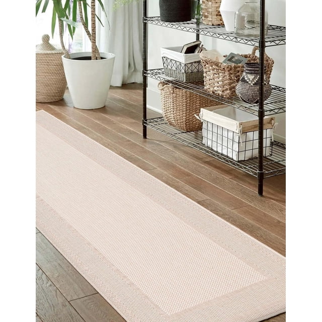 ECARPET Modern Area Rug for Living Room, Dining Room and Bedroom Jute Natura Collection in beige, displayed as a runner rug on hardwood floors beside a black metal shelving unit with woven baskets and a white planter with a green plant, featuring durable jute construction suitable for indoor use and often used to add natural texture to hallways or entryways.