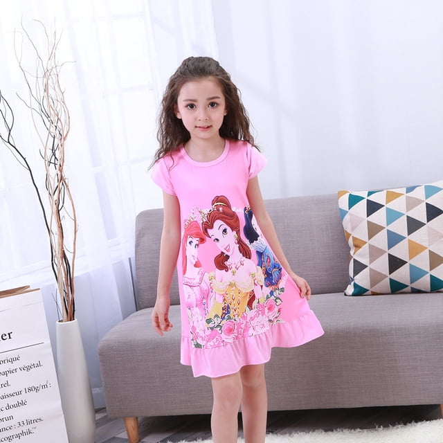 Toddler Night Gown Little Girls Princess Pajamas Dress in pink, featuring a vibrant design of princess characters and floral patterns. Made from soft cotton fabric with a lightweight and comfortable fit, this nightgown is suitable for girls aged 4-6 years. Ideal for bedtime, dress-up, or special occasions like birthdays and parties. The gown is displayed on a young girl in a cozy indoor setting with a sofa and decorative pillows in the background.