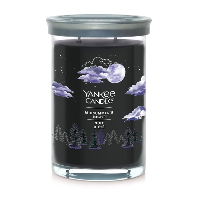Yankee Candle Scented Candle, Midsummer's Night, 20 oz Signature Large Tumbler with black wax in a clear glass jar featuring hand-illustrated purple clouds, a full moon, and pine trees, topped with a brushed tin lid that serves as a coaster. It has two cotton wicks and a premium soy wax blend for a clean burn, suitable for creating a relaxing home ambiance.