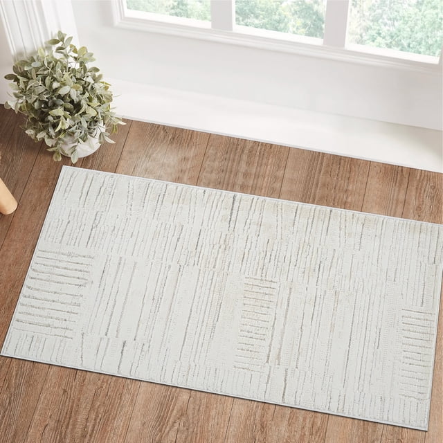 Rug Branch Astra Modern Indoor Area Rug in beige cream with an abstract linear pattern, placed on a hardwood floor near a window and a potted plant, ideal for living room, bedroom, dining room, and kitchen use.