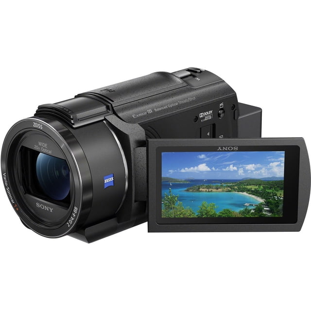 Sony FDR-AX43A UHD 4K Handycam Camcorder - FDR-AX43A/B featuring a compact black design with a ZEISS Vario-Sonnar T lens and a 3-inch tilting touchscreen LCD displaying a vibrant landscape. The camcorder includes a built-in gimbal with Balanced Optical SteadyShot stabilization, a 1/2.5-inch Exmor R CMOS sensor for low-light performance, and 20x optical zoom. Ideal for capturing UHD 4K video at 24 or 30 fps and 16.6MP still photos. Positioned on a white background.
