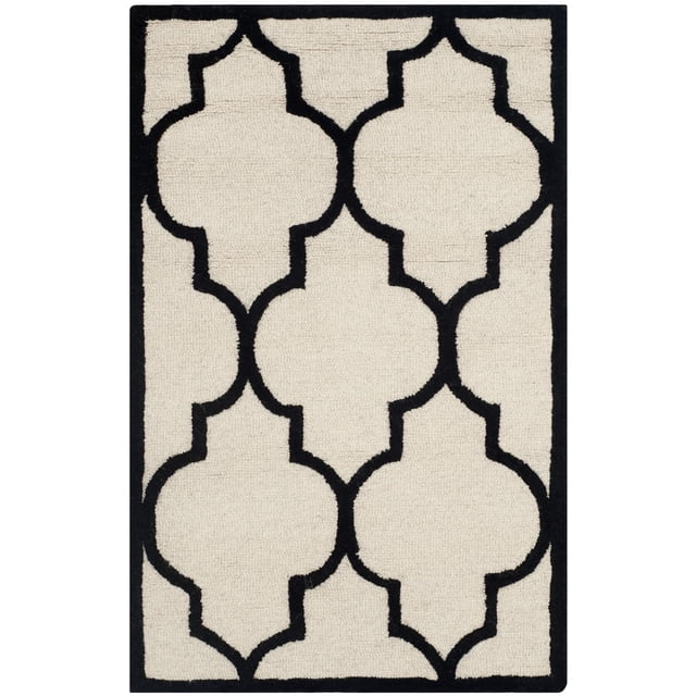 Safavieh Cambridge Kevin Geometric Area Rug with a front-facing view of a hand-tufted wool rug in cream featuring a black geometric trellis pattern and black border, ideal for accent use in home or office, often used as a decorative floor piece in entryways or reading areas.
