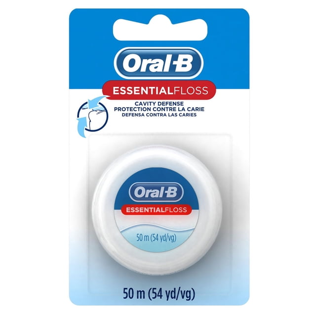 Oral-B EssentialFloss Cavity Defense Dental Floss in a white circular spool containing 50 meters (54 yards) of wax-coated, shred-resistant floss designed to remove plaque and protect against cavities, displayed on a blue and white blister card with bilingual English and French text.
