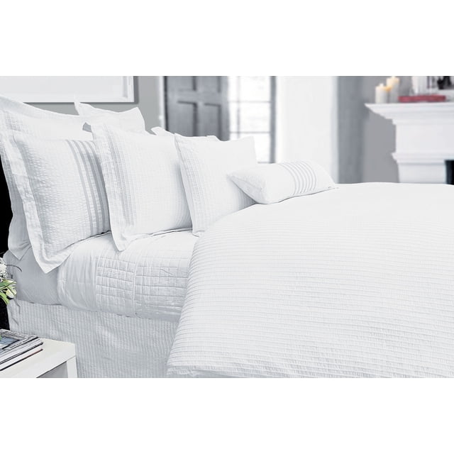 Dorchester white bedskirt in double size, measuring 54x75x14 inches, made from 100% cotton. The bedskirt features elegant rope and ruching details, complementing the calm and inviting white bedding set. Displayed in a bright bedroom setting with matching white pillows and duvet.
