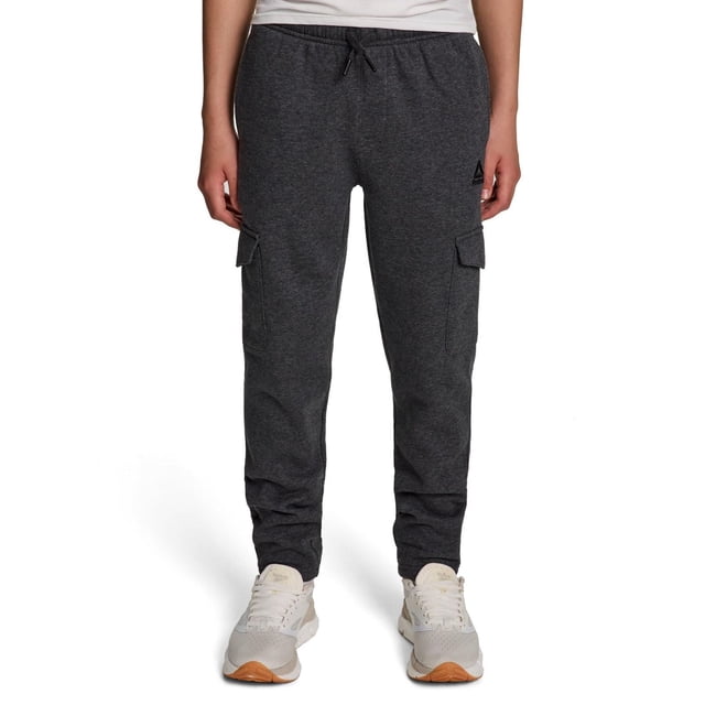 Boys' dark gray Reebok Unwind cargo pants featuring side flap pockets, elastic waistband with drawstring, worn with white athletic shoes.