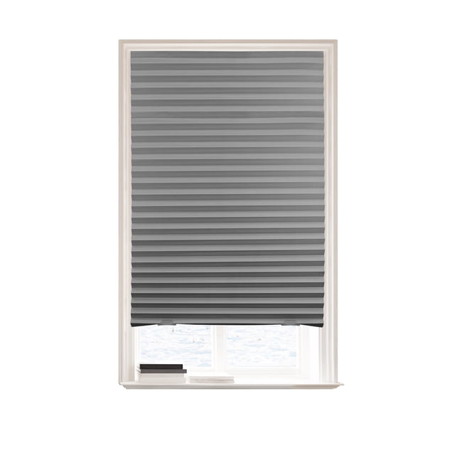 Mainstays Cordless Pleated Paper Shades in grey, 36" x 72", shown fully lowered on a white window frame with a small ledge holding two books, featuring a room-darkening pleated paper design with a cordless EZ Clip System for easy, nail-free installation and adjustable width up to 36 inches, ideal for privacy and light blocking.