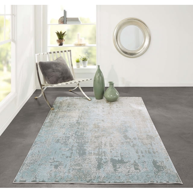 ECARPET Elysia Traditional Area Rug for Living Room, Bedroom, Dining Room, Entrance, Hallway and More with a transitional ornamental medallion pattern and border in washed light blue, dove grey, and ivory on durable synthetic fibers, displayed in a minimalist room with a white metal chair with grey cushion, two green ceramic vases, a round silver mirror, and a white shelf with plants and candles, ideal for high-traffic home areas.